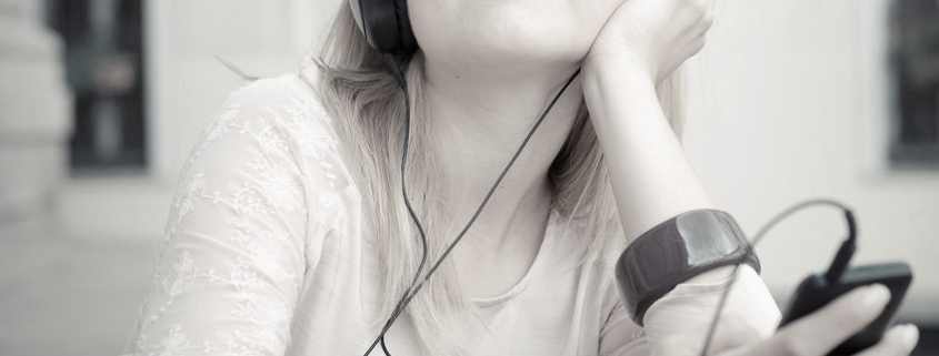 A young girl listening to music with headphones.